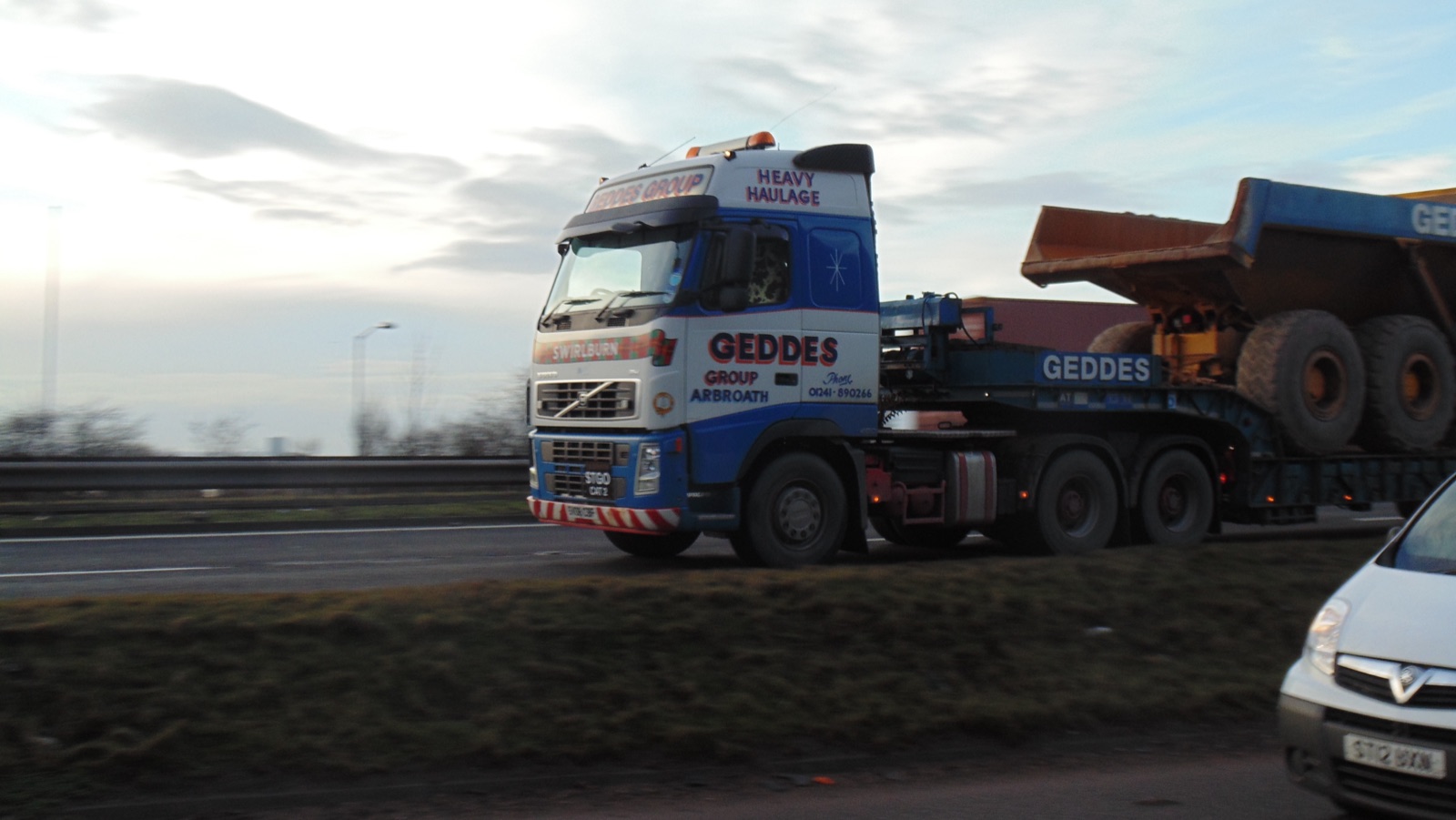 European Volvo FH cab-over heavy-haul truck towing a low-loader