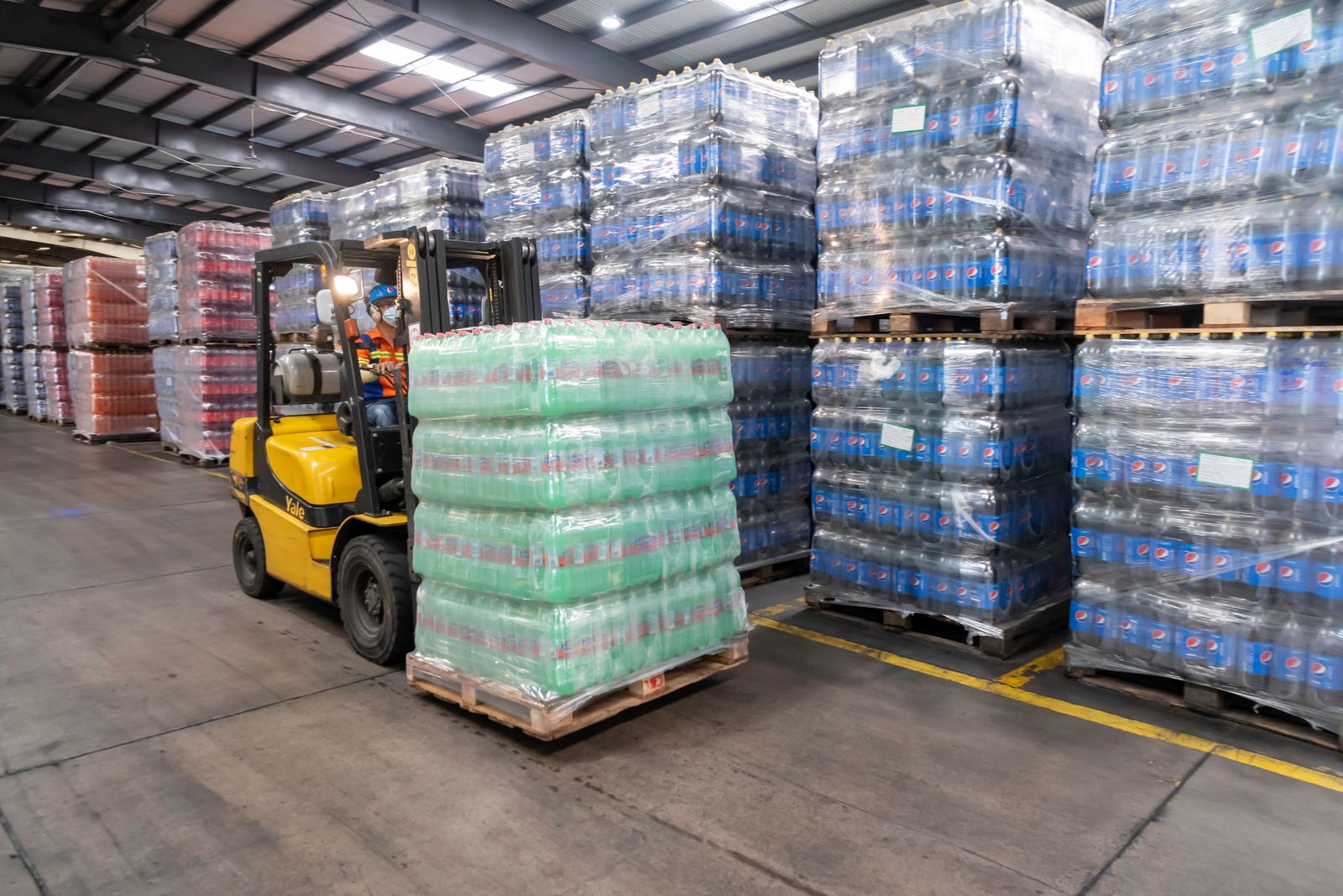Forklift moving loaded pallets inside a warehouse